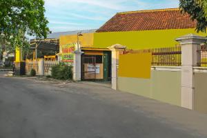 une rue vide devant un bâtiment jaune dans l'établissement OYO 92593 Penginapan Sultan Haji 1, à Bandar Lampung