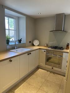 a kitchen with a sink and a stove at The Beeches - Chatsworth Apartment No 3 - Sleeps 4 in Baslow