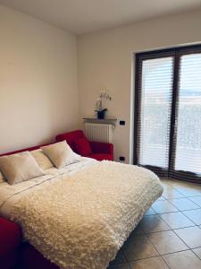 a bedroom with a large bed and a red chair at Bellavista Bobbio in Bobbio