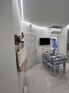 una sala da pranzo con un tavolo con sedie e una televisione di beach house a Chioggia