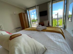 a large bed in a room with large windows at Le Relais De La Place in Le Faou