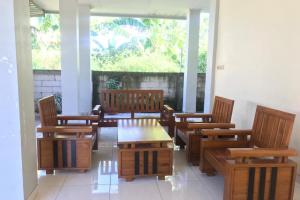 una camera con sedie in legno e tavolo di OYO 92608 Penginapan Mc Lodge a Labuan Bajo