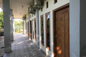 una fila de puertas en el lateral de un edificio en OYO 92608 Penginapan Mc Lodge en Labuan Bajo