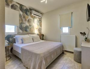Schlafzimmer mit einem Bett mit weißer Bettwäsche und Kissen in der Unterkunft Diogia Luxury Apartment in Vanáton