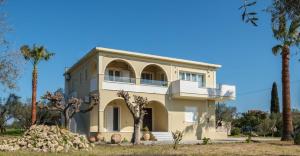 a house with palm trees in front of it at Diogia Luxury Apartment- Comfort & Elegance, by ZanteWize in Vanáton