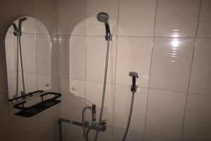 y baño con ducha y espejo. en OYO 92608 Penginapan Mc Lodge, en Labuan Bajo