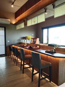 un bar avec des chaises et un long comptoir dans un restaurant dans l'établissement Jiaoxi Pusu Homestay, à Jiaoxi