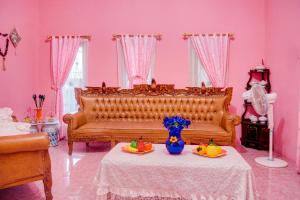 a living room with a couch and a table with fruit on it at OYO 92598 Sulthan Homestay Syariah 3 in Palembang