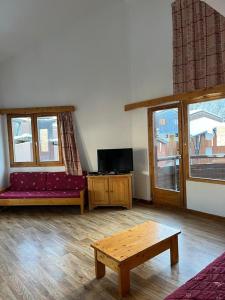 a living room with a couch and a table at La Tania La Saboia sleep 8 private Sauna lounge dining 2 bathrooms kitchen 2 balconies ski in out in La Tania