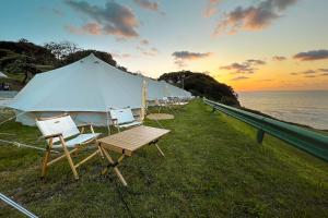 una fila di sedie e una tenda vicino all'oceano di Kampaoh Las Arenas a Pechón