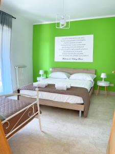 a bedroom with a bed with a green wall at Vittory house in Lido di Ostia