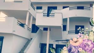a white building with blue doors and flowers on it at Apartments Linic in Nin