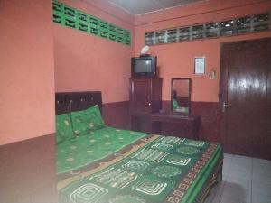 um quarto com uma cama e uma televisão em SPOT ON 92601 Penginapan Keluarga em Medan