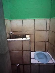uma casa de banho suja com um WC azul no chão em SPOT ON 92601 Penginapan Keluarga em Medan