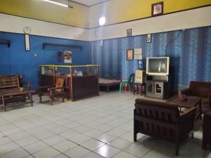 uma sala de estar com mobiliário e uma televisão em SPOT ON 92601 Penginapan Keluarga em Medan
