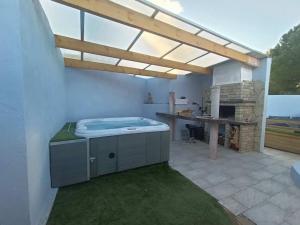 a patio with a hot tub and a table at Appartement Le Secret Spa billard sensualité in Espondeilhan