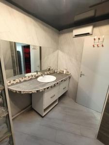 a bathroom with a sink and a mirror at Appartement Le Secret Spa billard sensualité in Espondeilhan