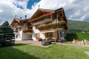 a house with flowers on the side of it at Appartamento Mansarda Patrizia e Franco Val di Sole in Deggiano