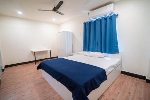 a bedroom with a bed with a blue curtain at Slackpackr Hyderabad in Hyderabad
