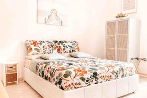 a bedroom with a bed with a floral bedspread at Locazione turistica Davide in Anzio
