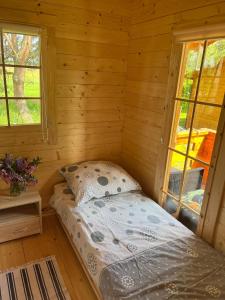 sypialnia z łóżkiem w drewnianym domku w obiekcie Domki Radków w mieście Radków