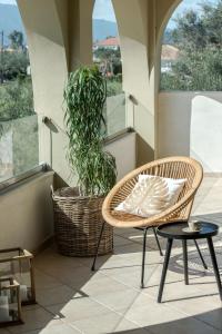 Diogia Luxury Apartment في Vanáton: بلكونه فيها كرسيين ومصنع خزاف