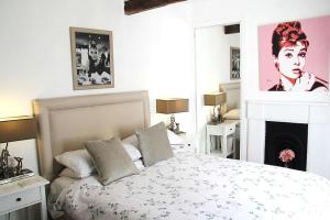 a white bedroom with a bed and a fireplace at Sommersway Cottage in Torquay