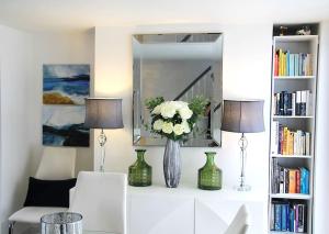 uma sala de estar com dois candeeiros e um vaso com flores em Sommersway Cottage em Torquay