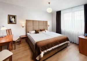 a hotel room with a large bed and a desk at Hotel Bešeňová in Bešeňová