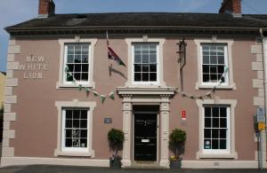 una casa rosa con un cartel que lee la lamida blanca en The New White Lion en Llandovery