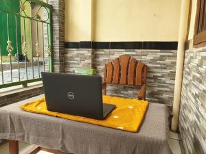 a laptop computer sitting on a table with a chair at OYO Life 92620 Syfa Kost in Malang