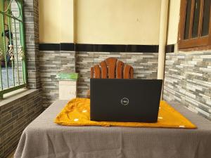 a laptop computer sitting on a table with a chair at OYO Life 92620 Syfa Kost in Malang +30 photos