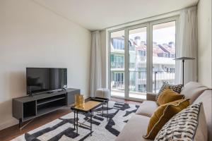 salon z kanapą i telewizorem z płaskim ekranem w obiekcie Upscale Apartment in City Center by LovelyStay w Lizbonie