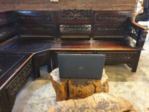 laptopa siedzącego na drewnianym pianinie w obiekcie OYO Life 92622 Jatiluhur Kost Syariah w mieście Malang