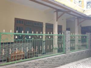 a green fence with birds on it in front of a building at OYO Life 92620 Syfa Kost in Malang