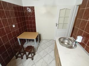 ein Badezimmer mit einem Waschbecken und einem Tisch mit zwei Stühlen in der Unterkunft Lipowy Przylądek- Domek 21 