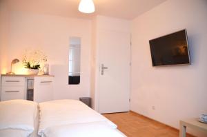 1 dormitorio con 1 cama y TV en la pared en Bałtyckie-Hel, en Hel