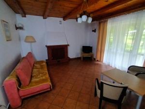 ein Wohnzimmer mit einem Sofa und einem Tisch in der Unterkunft Lipowy Przylądek- Domek 21 