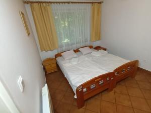 Schlafzimmer mit einem Bett mit weißer Bettwäsche und einem Fenster in der Unterkunft Lipowy Przylądek- Domek 21 