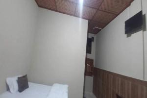 Habitación pequeña con cama y techo en OYO 92629 Pondok Kawandya, en Karanganyar