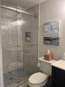 a bathroom with a toilet and a glass shower at Edgartown Commons Vacation Apartments in Edgartown