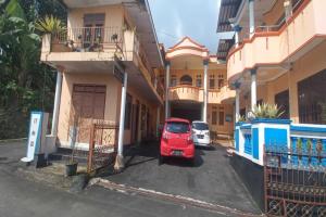 a red car parked in a parking lot in front of a building at OYO 92631 Hotel Dan Aula Wahyu Sari B in Karanganyar