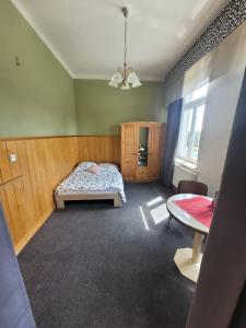 Un dormitorio con una cama y una mesa. en Pension Schützenhaus Leisnig, en Leisnig