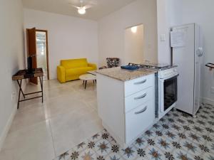 uma cozinha com um fogão e um sofá amarelo em Apartamento Felipe de Oliveira no Rio de Janeiro