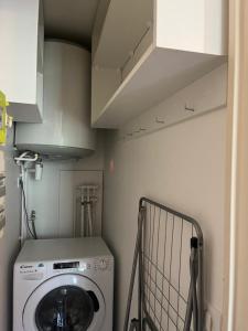 eine kleine Waschküche mit Waschmaschine in der Unterkunft le petit prince , jolie maisonnette terrasse Netflix parking privé jeux de société in Bourg-en-Bresse