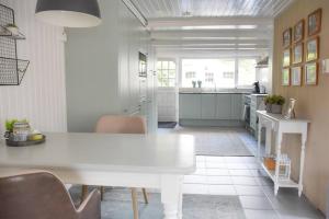 a white kitchen with a white table and chairs at Cosy forest hideout @ Veluwe in Putten