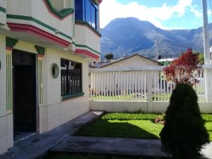 una casa con una valla blanca y un patio en Otavalo Ecuador (casa familiar), en Otavalo
