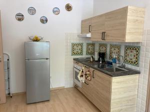 kuchnia z lodówką i szafkami ze stali nierdzewnej w obiekcie casa vacanza brezza di maestrale w mieście Salerno