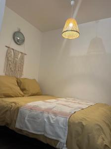 ein Schlafzimmer mit einem Bett und einer Uhr an der Wand in der Unterkunft le petit prince , jolie maisonnette terrasse Netflix parking privé jeux de société in Bourg-en-Bresse