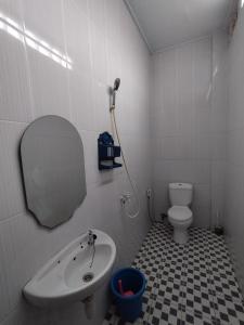 a bathroom with a sink and a toilet and a mirror at OYO Life 92637 Kost Arya Exclusive in Jambi